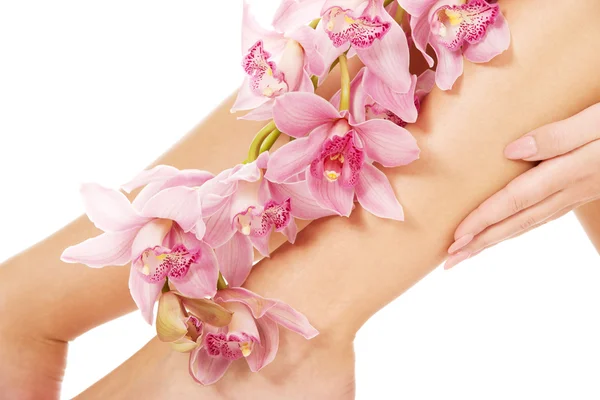 Nogi kobiety z różowe kwiaty. — Zdjęcie stockowe