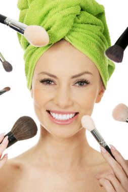 Genç kadın yüz çevresinde fırçaları vardır.