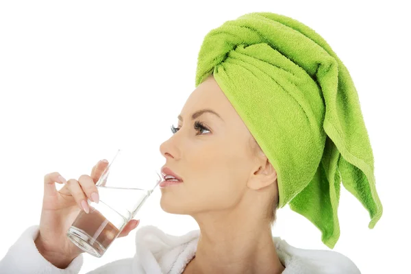 Woman in bathrobe drinks water. — Stock Photo, Image