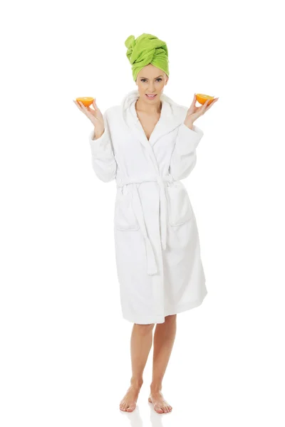 Spa woman in bathrobe holding orange. — Stock Photo, Image