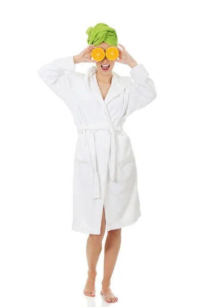 Spa woman in bathrobe with orange halves. — Stock Photo, Image