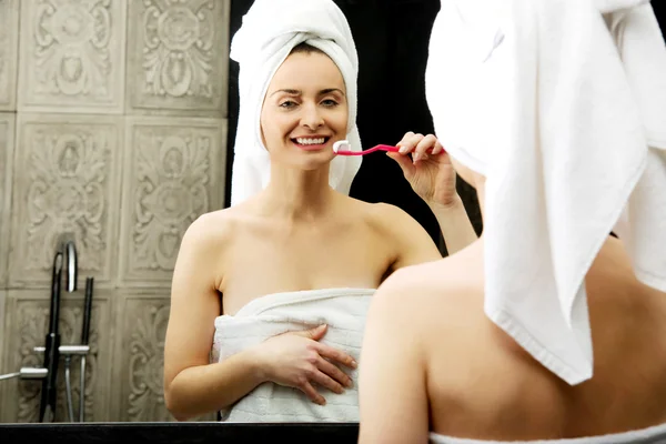 Mujer cepillarse los dientes en el baño. — Foto de Stock