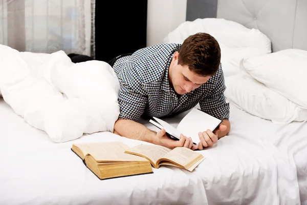 Un uomo premuroso con un libro nel suo letto . — Foto Stock