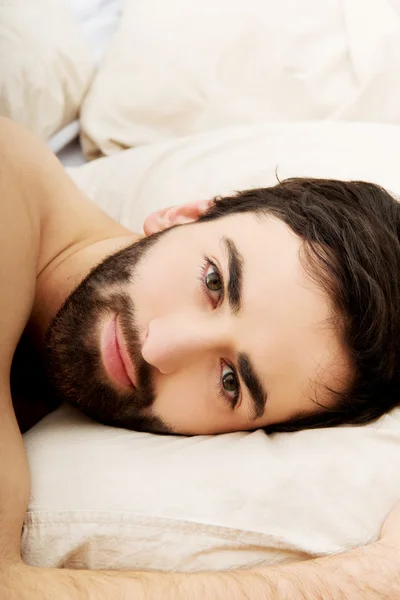 Jovem homem musculoso deitado na cama. — Fotografia de Stock