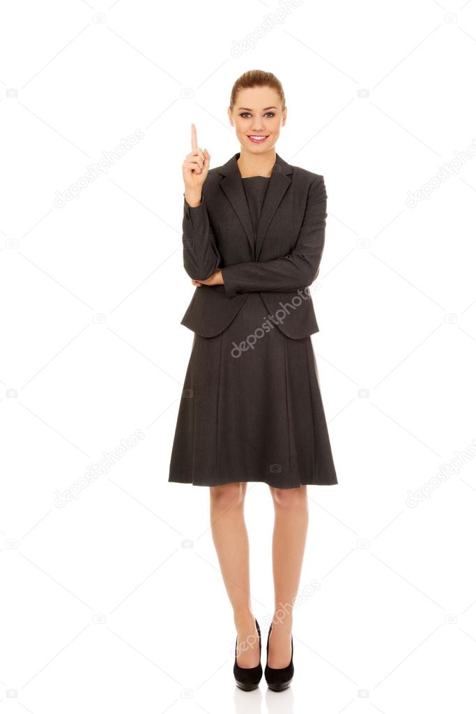 Young businesswoman pointing up.