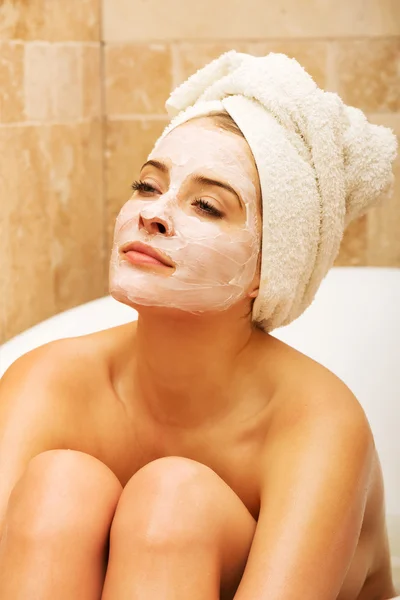 Woman relaxing in bath with face mask — Stock Photo, Image