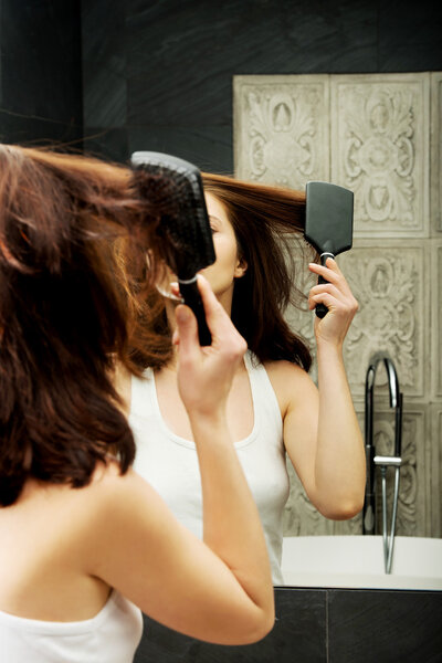 Brunette woman brushing her hair.