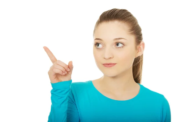 Mujer joven sonriente señalando hacia arriba. — Foto de Stock