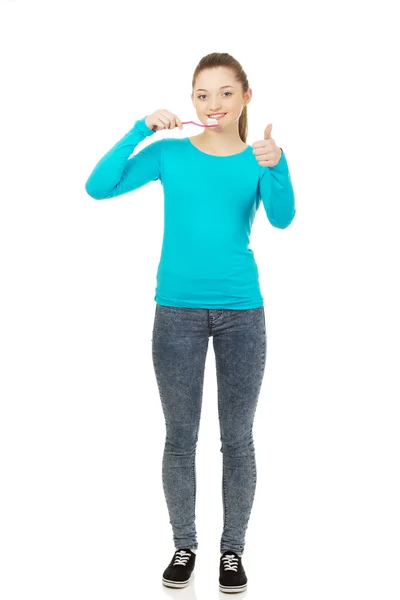 Mujer joven cepillándose los dientes. — Foto de Stock