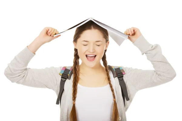 Adolescente chica con libro sobre su cabeza . — Foto de Stock