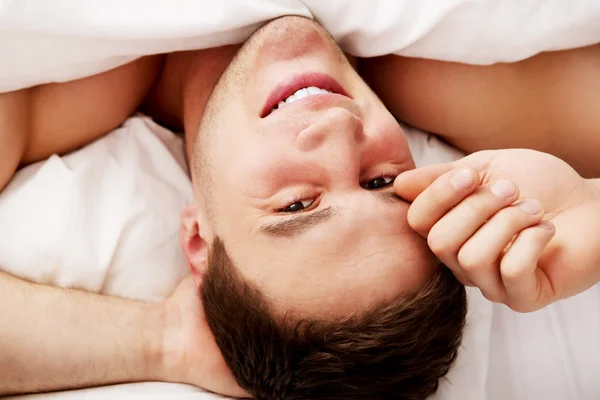 Schöner junger Mann liegt im Bett. — Stockfoto