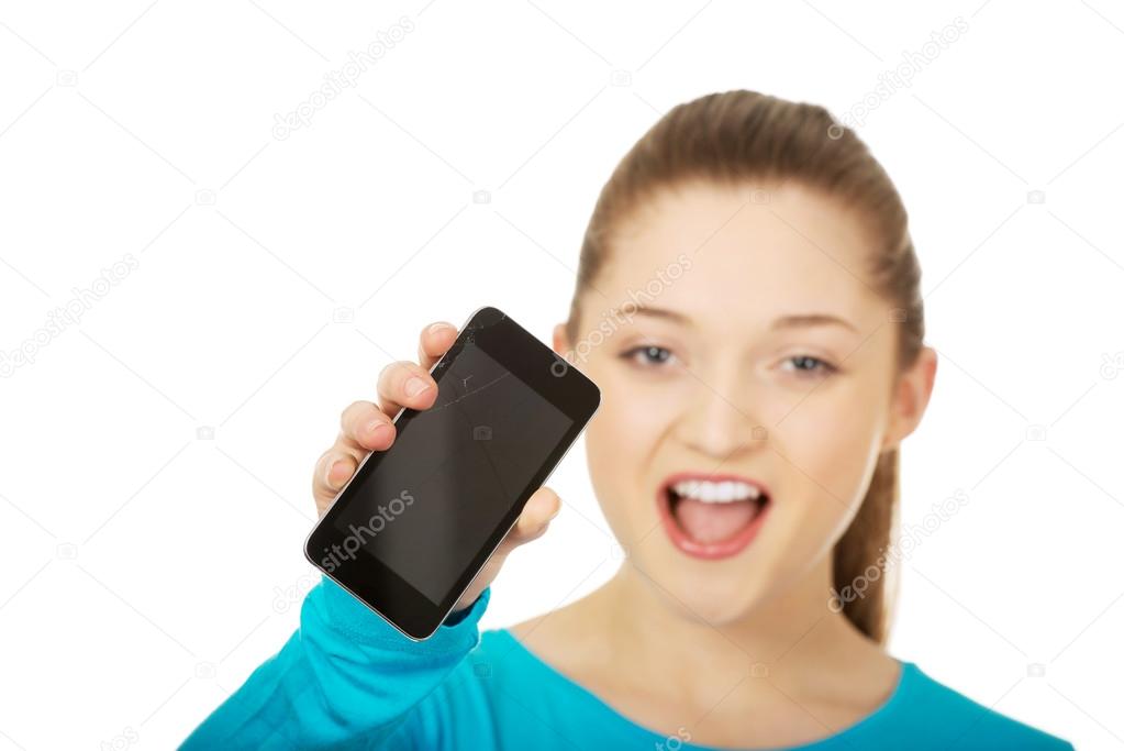 Teen woman with a broken cell phone.