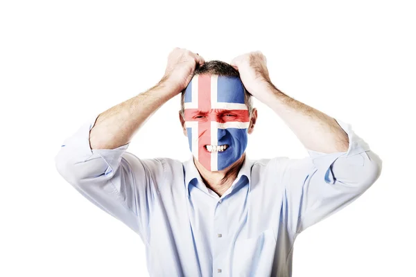 Зрелый человек с исландским флагом на лице . — стоковое фото