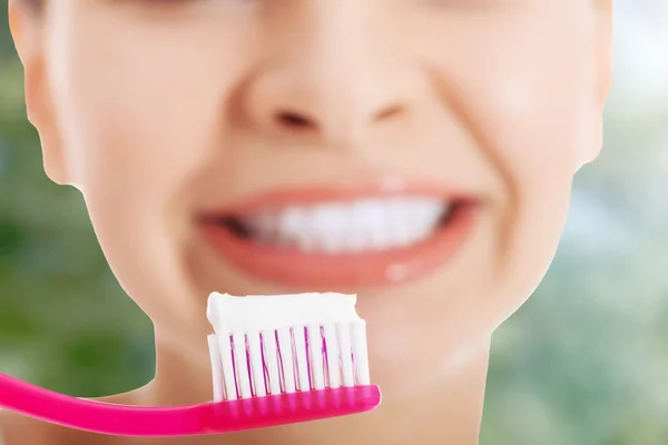 Senhora segurando escova de dentes e sorrindo . — Fotografia de Stock