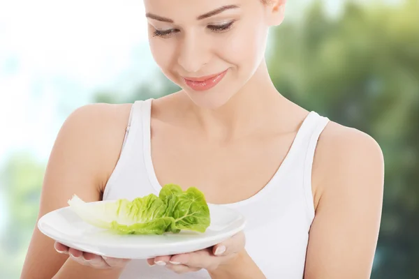 Frau mit Salat auf einem Teller. — Stockfoto
