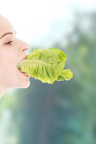 Frau isst Salatblatt. — Stockfoto