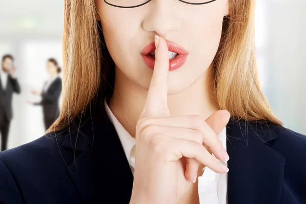 Geschäftsfrau mit dem Finger auf den Lippen. — Stockfoto