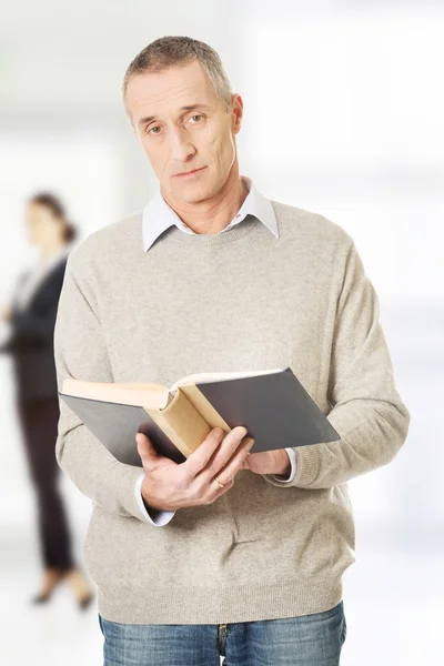 Gammal man läser en bok. — Stockfoto