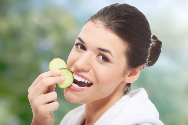Donna in accappatoio mangiare cetriolo . — Foto Stock
