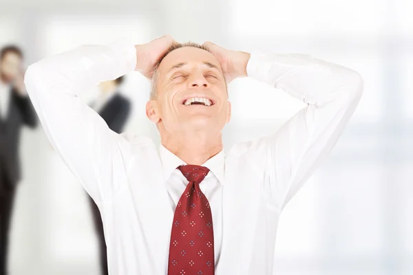 Cheerful businessman holding his head. — Stock Photo, Image