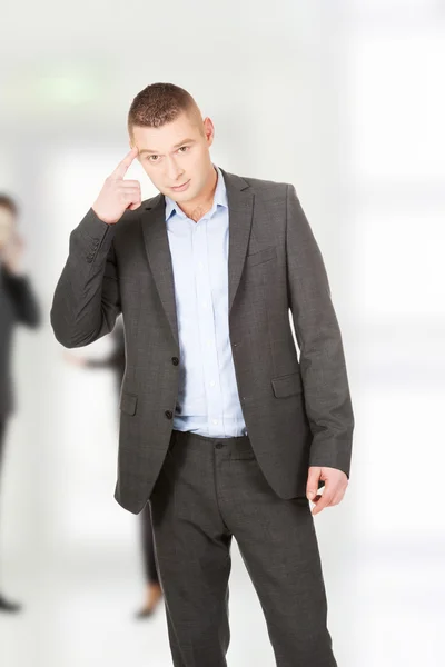 Man gebaren zijn vinger tegen Tempel. — Stockfoto