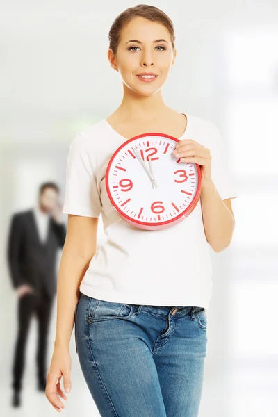 Mujer joven con un reloj. — Foto de Stock