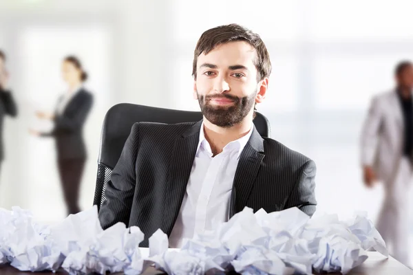 Businessman sitting with crushed sheets. — Stock Photo, Image