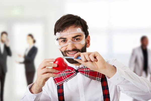 Determined man cutting heart model with scalpel. — Stock Photo, Image