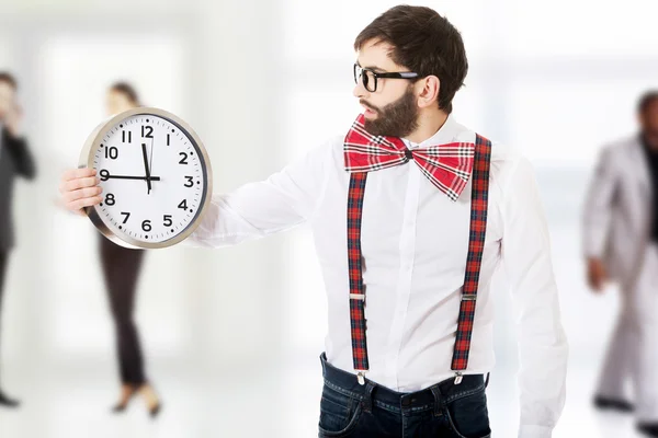 Man wearing suspenders holding big clock. — Stock Photo, Image