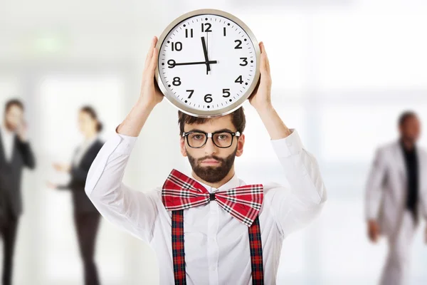 Man in suspenders holding big clock. — Stock Photo, Image