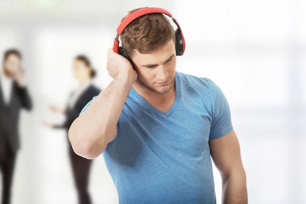Pohledný muž poslouchající hudbu se sluchátky. — Stock fotografie