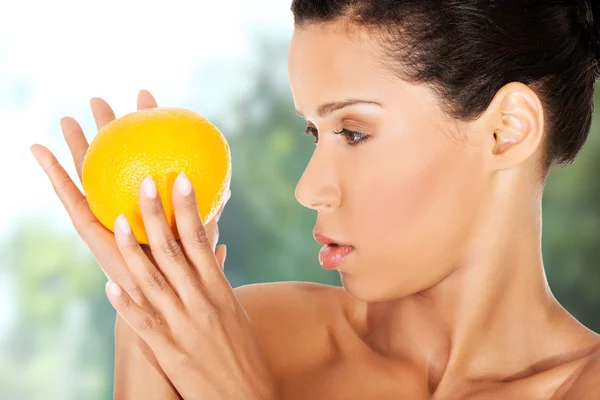 Piękna kobieta trzyma pomarańczę. — Zdjęcie stockowe