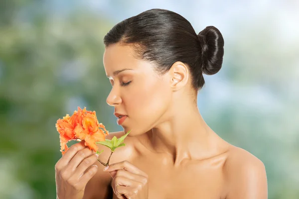 Beauty woman smelling orange flower.