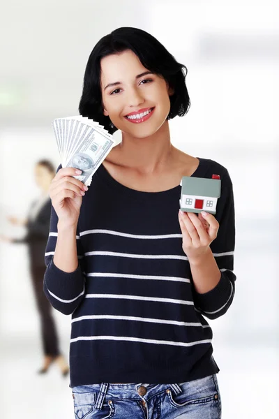 Mujer sosteniendo billetes de dólar y casa . —  Fotos de Stock