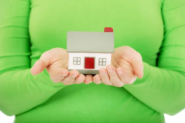 Mujer sosteniendo pequeña casa . — Foto de Stock