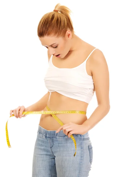 Shocked woman measuring her waist. — Stock Photo, Image