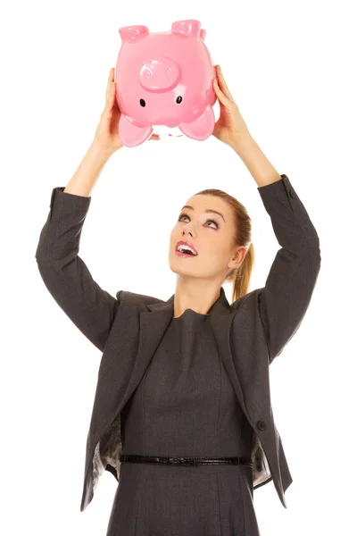 Geschäftsfrau schüttelt Sparschwein. — Stockfoto