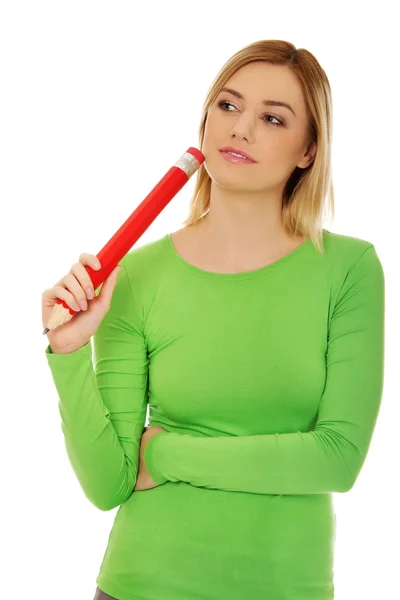 Thoughtful woman with big pencil. Royalty Free Stock Images