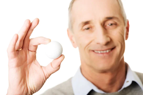 Mature man holding golf ball — Stock Photo, Image