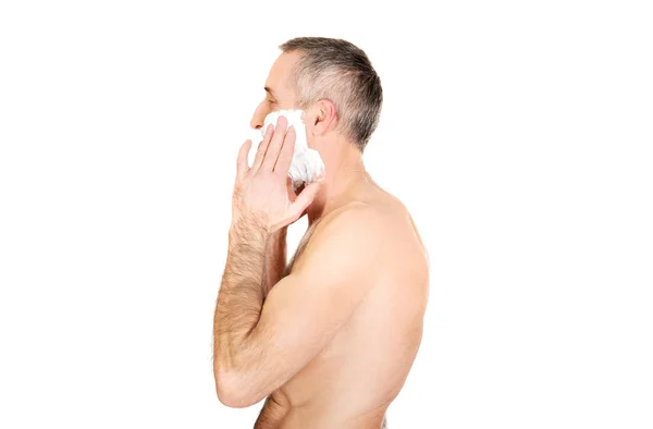 Vista lateral de un hombre que aplica espuma de afeitar — Foto de Stock