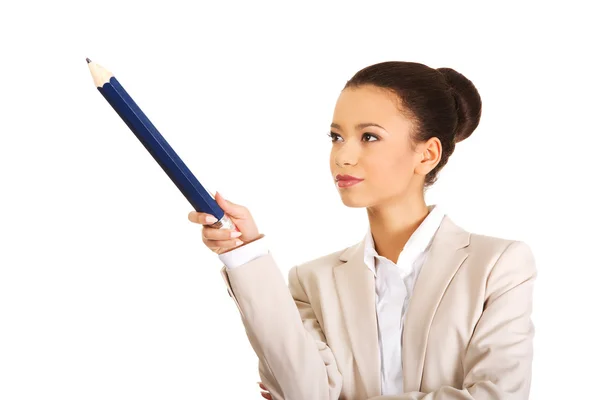 Businesswoman pointing up with big pencil. — Stock Photo, Image