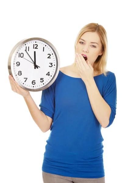 Mujer cansada sosteniendo un reloj . — Foto de Stock