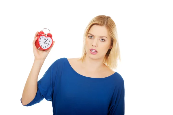 Shocked woman holding a clock. — Stock Photo, Image