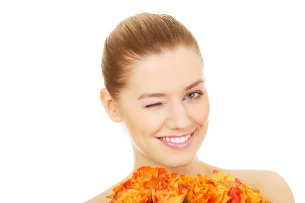 Lächelnde Frau mit frischen Rosen. — Stockfoto