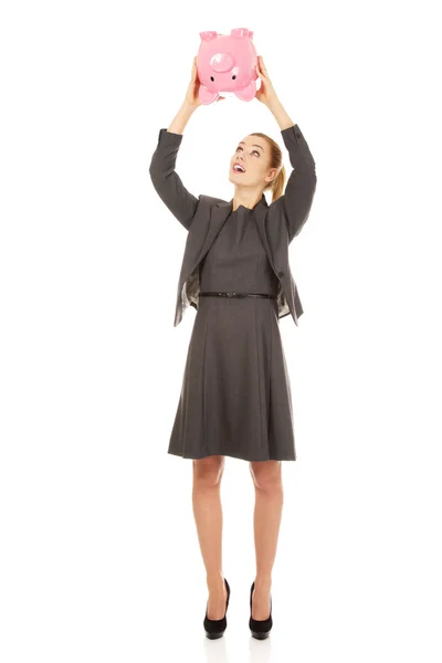 Business woman shaking a piggybank. — Stock Photo, Image