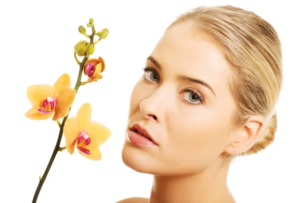 Prachtige spa vrouw met oranje orchid — Stockfoto