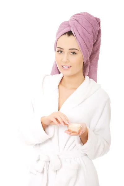 Woman in bathrobe with cream moisturizer. — Stock Photo, Image