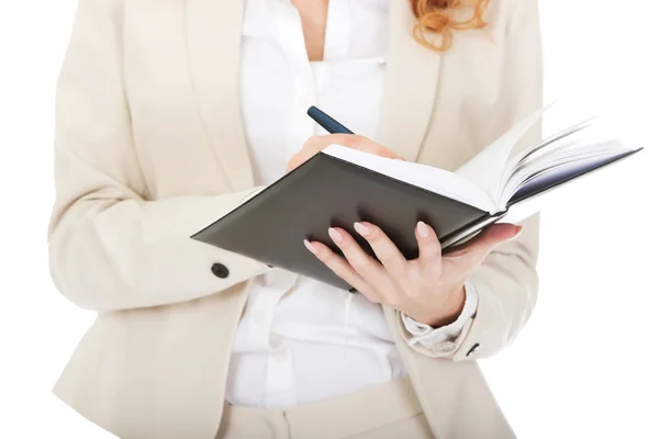 Businesswoman writing in a note. — Stock Photo, Image