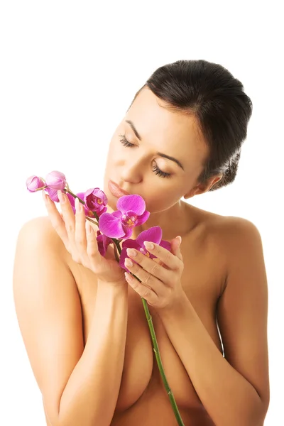 Topless kvinna med lila orkidé gren — Stockfoto