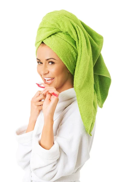 Woman in bathrobe brushing teeth — Stock Photo, Image